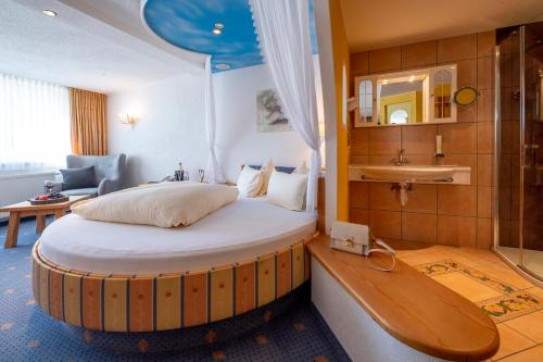 a bedroom with a bed and a sink in a room at Hotel Bergkristall in Silbertal