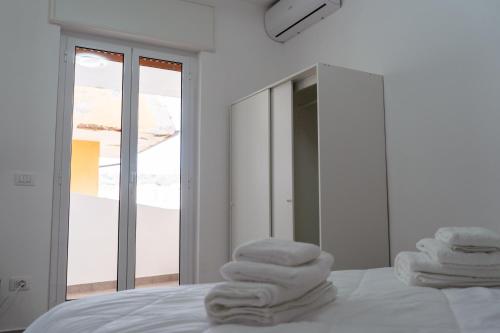 a pile of towels sitting on top of a bed at Mulino Suites in Scalea