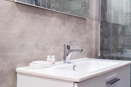 a bathroom with a sink and a mirror at Mulino Suites in Scalea