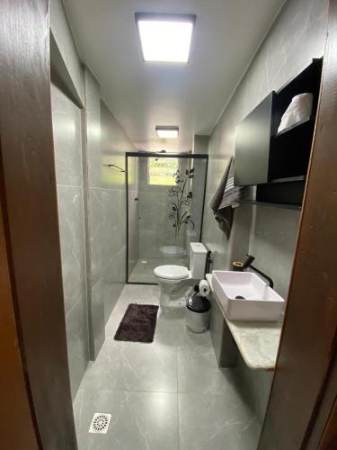 a bathroom with a shower and a toilet and a sink at Suítes no centro Histórico Diamantina in Diamantina