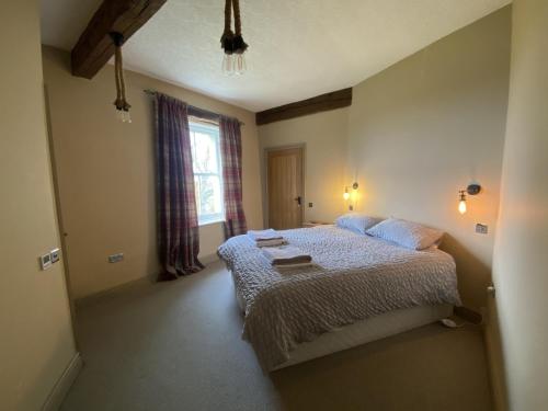 a bedroom with a bed and a window at The Hideaway Embleton in Embleton