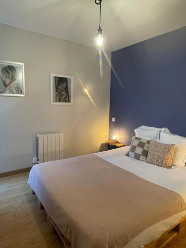 a bedroom with a large bed with a blue wall at Les oiseaux de la Slack in Ambleteuse