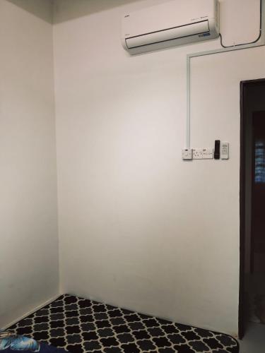 a room with a white wall and a black floor at HAIZRINA HOMESTAy in Sungai Petani