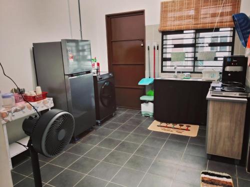 a kitchen with a refrigerator and a sink at HAIZRINA HOMESTAy in Sungai Petani