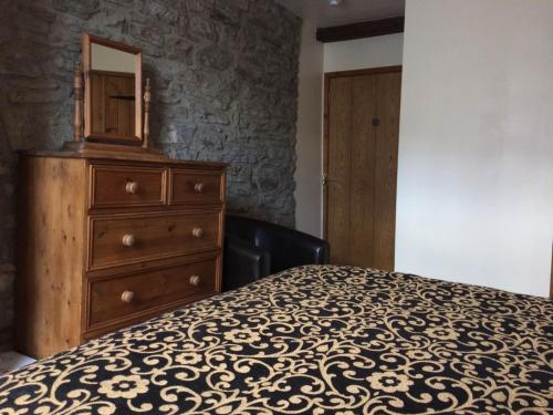 a bedroom with a dresser and a bed with a mirror at The White Horse Inn, Clun in Clun