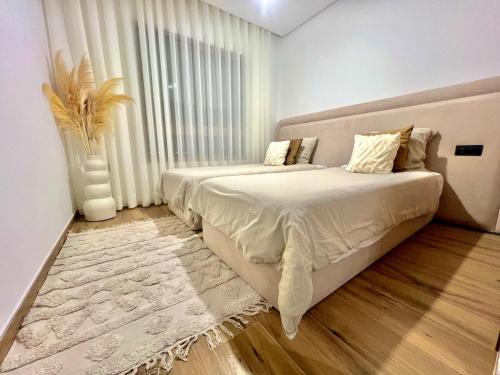 a bedroom with two beds and a vase at Marrakech golf City prestigia in Marrakesh