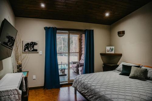 a bedroom with a bed and a large window at Big Bear Chalet and spa in Revelstoke