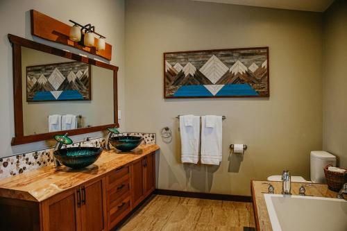 a bathroom with two sinks and a large mirror at Big Bear Chalet and spa in Revelstoke