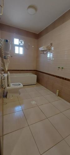 a bathroom with a toilet in a hospital room at كيان الين للشقق المخدومة in Abha