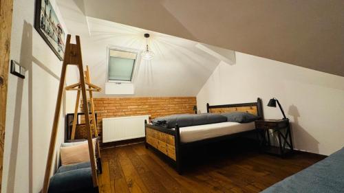 a attic room with a bed and a window at Apartmany FABRIK in Vysoká nad Kysucou