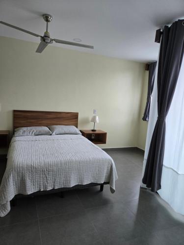 a white bedroom with a bed and a window at Departamento Huatulco 1 Torre Bel in Santa Cruz Huatulco