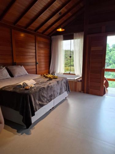 a bedroom with a bed and a large window at Chales Vista da Mata 01 in Santa Teresa