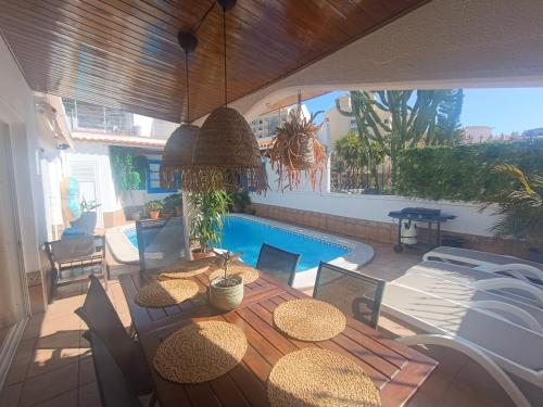 a patio with a table and chairs and a swimming pool at Beautiful Holiday Villa with heated private pool, Los Cristianos in Los Cristianos