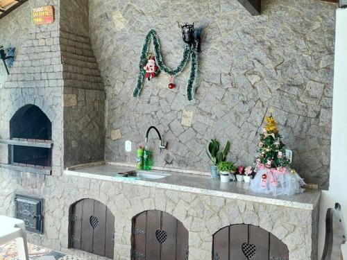 a fake kitchen with a stove and a christmas tree at Pousada Summer Beach by Itaúna in Saquarema