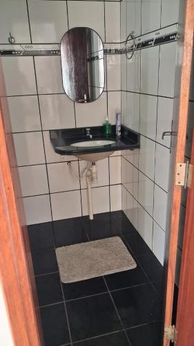 a small bathroom with a sink and a mirror at Santos & Oliveira in Diamantina