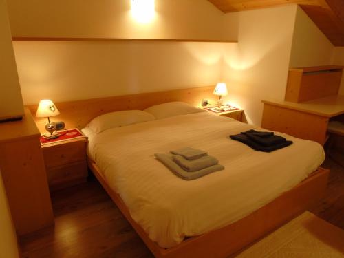 a bedroom with a bed with two towels on it at Apartments Trettel in Tesero