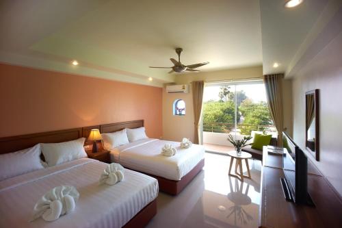 a hotel room with two beds and a balcony at Villa Blanca Hotel & Restaurant in Chao Lao Beach