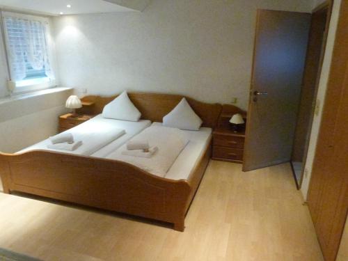 a bedroom with a large bed with two pillows on it at Winzergasthof zum Kellerstübchen in Mehring