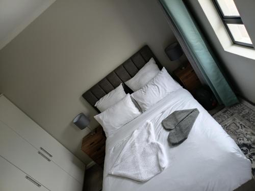 a bedroom with a bed with white sheets and pillows at Coastal Guest House with Free Parking and Braai Area in Cape Town
