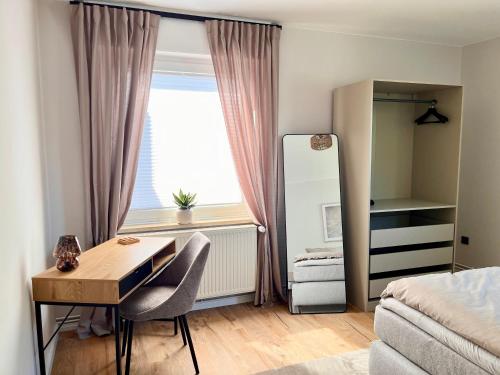 a small bedroom with a desk and a window at CozyHome mit Netflix, voll ausgestatteter Küche, Zentrums- und Bahnhofsnah, Balkon, self-Check-in möglich in Bückeburg