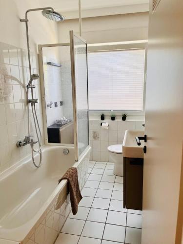 a bathroom with a tub and a toilet and a sink at CozyHome mit Netflix, voll ausgestatteter Küche, Zentrums- und Bahnhofsnah, Balkon, self-Check-in möglich in Bückeburg