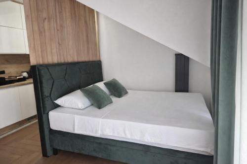 a bed with two pillows on it in a room at Lana Apartmani Autor in Tuzla