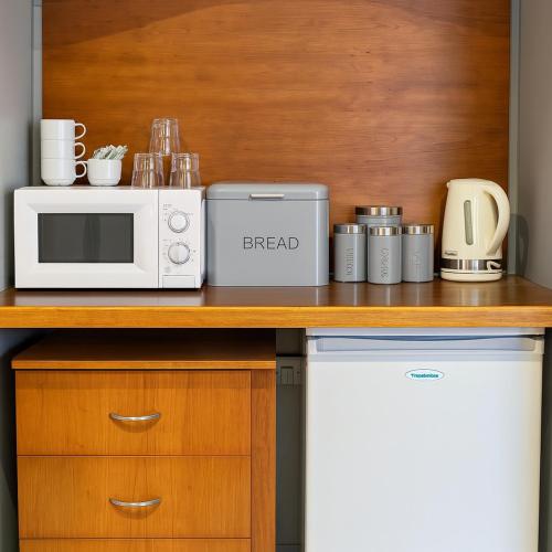 a kitchen counter with a microwave and a appliance at The Hand Hotel in Chirk