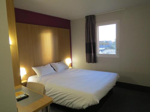 une chambre d'hôtel avec un lit et une fenêtre dans l'établissement B&B HOTEL Yvetot, à Yvetot