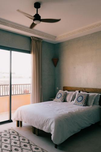a bedroom with a large bed with a ceiling fan at Mish Mish in Tamraght Ouzdar