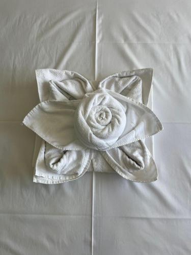 a white flower made out of towels on a bed at Hijo Buriti Hotel in Mauriti
