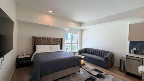 a bedroom with a bed and a couch at Luxury Walk of Fame Studio in Los Angeles