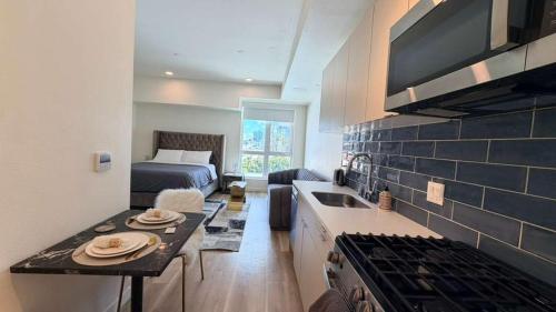 a room with a kitchen and a bedroom with a bed at Luxury Walk of Fame Studio in Los Angeles