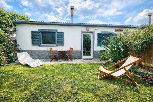 a patio with chairs and a table in front of a house at Sea Roots "Garden Zone " in Mosteiros