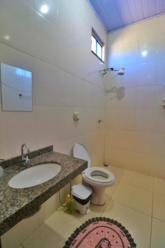 a bathroom with a sink and a toilet at Lolt Vila Boa Goiás in Goiás