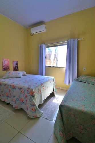 a bedroom with two beds and a window at Lolt Vila Boa Goiás in Goiás