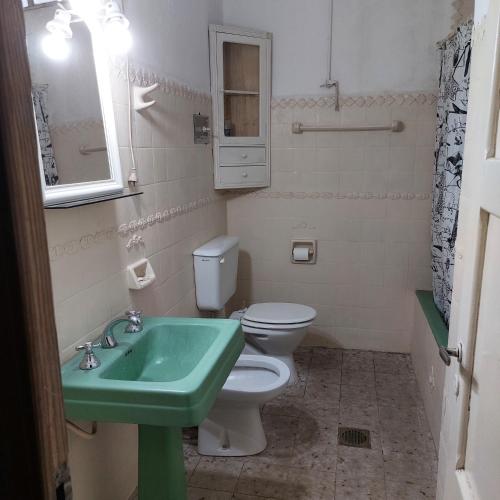 a bathroom with a green sink and a toilet at Casona El Olivo in Villa Krause
