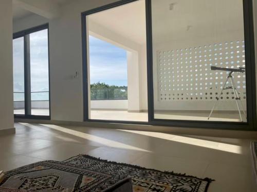 a room with a large window and a rug on the floor at Bustani Villa in Nyamanzi Kazole