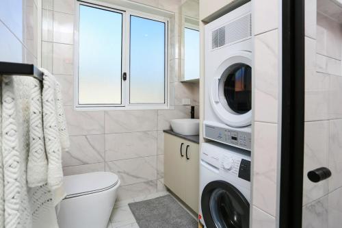 a bathroom with a washer and dryer at The Modern Retreat in Sydney