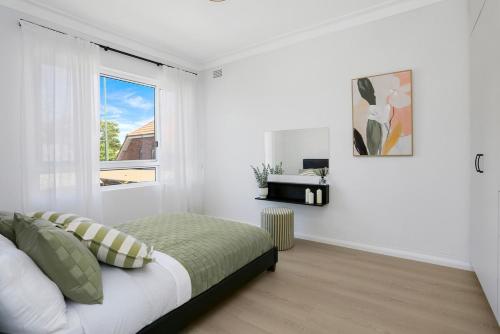 a white bedroom with a bed and a window at The Modern Retreat in Sydney