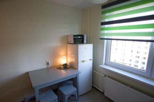 a small kitchen with a white refrigerator and a table at Apartments in Kauguri in Jūrmala
