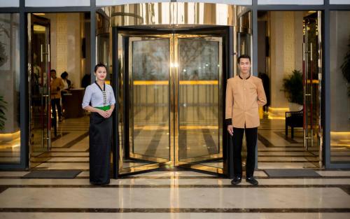 two people standing in front of a revolving door at Muong Thanh Luxury Nhat Le Hotel in Dong Hoi