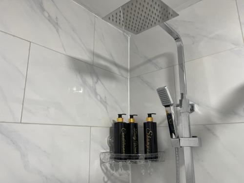 a group of three black bottles on a shelf in a bathroom at Princess shahzadi in Manchester