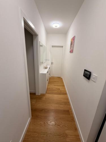 a hallway with a bathroom with a sink and a mirror at Apartman TERRASSE in Trebinje