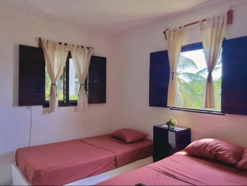 a bedroom with two beds and a window at Casa OMI in Brisas de Zicatela