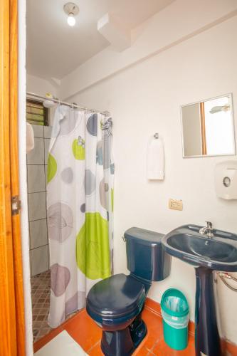 a bathroom with a toilet and a sink at Hostal Nuevo Arenal downtown, private rooms with bathroom in Nuevo Arenal