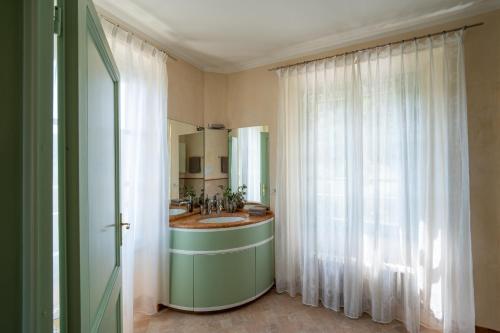 a bathroom with a sink and a mirror at Limonaia dei Dogi Entire 7BR Villa with Private Pool & Lake Garda View in Gargnano