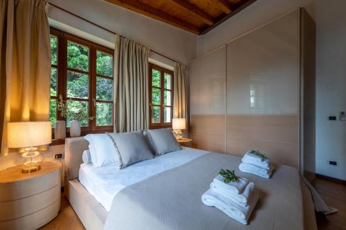 a bedroom with a large bed with towels on it at Limonaia dei Dogi Entire 7BR Villa with Private Pool & Lake Garda View in Gargnano