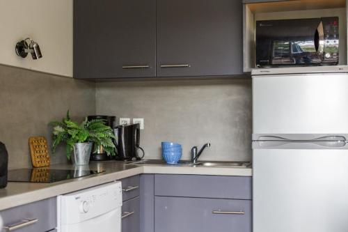 a kitchen with a white refrigerator and a sink at Les Collines Iduki in Labastide-Clairence