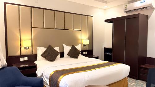 a bedroom with a large bed and a blue chair at فندق ذكرى in Taif