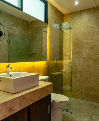 a bathroom with a sink and a toilet and a shower at Hotel Boutique Zoren in Tulum
